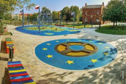 Auf dem Spielplatz der Nationen in Magdeburg gibt es auch ein rundes Trampolin (Vordergrund), das in Blau von der Flagge Europas mit den zwölf Sternen umrahmt wird.