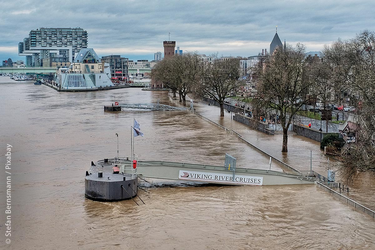 Das Rheinauhafen-Ufer in Köln steht unter Wasser – im Hintergrund sind die Kranhäuser zu sehen.