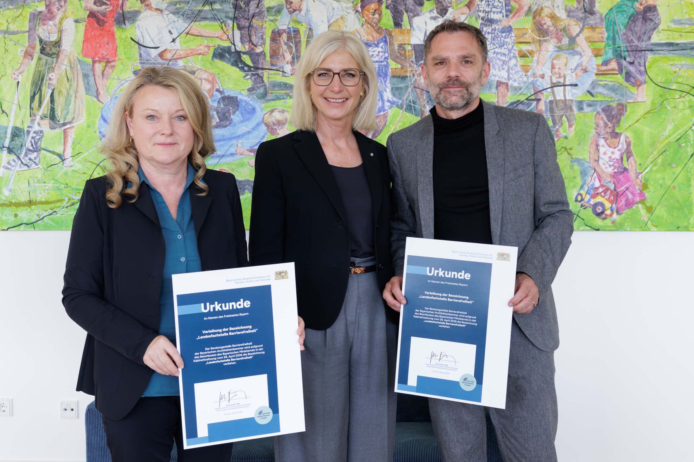 Bayerns Sozialministerin Ulrike Scharf bei der Übergabe des Prädikates „Landesfachstelle Barrierefreiheit“ an Prof. Lydia Haack,Präsidentin der Bayerischen Architektenkammer, und an Thomas Lenzen, Geschäftsführer Architektur und Technik der Bayerischen Architektenkammer.