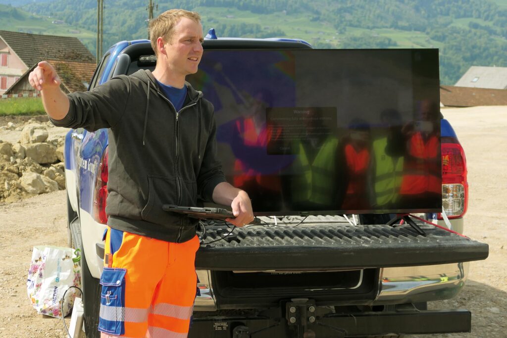 Arbeitsauftrag erteilt: Bauleiter Gabriel Hasler erläutert, mit welchen Daten er den DX225LC programmiert hat. 