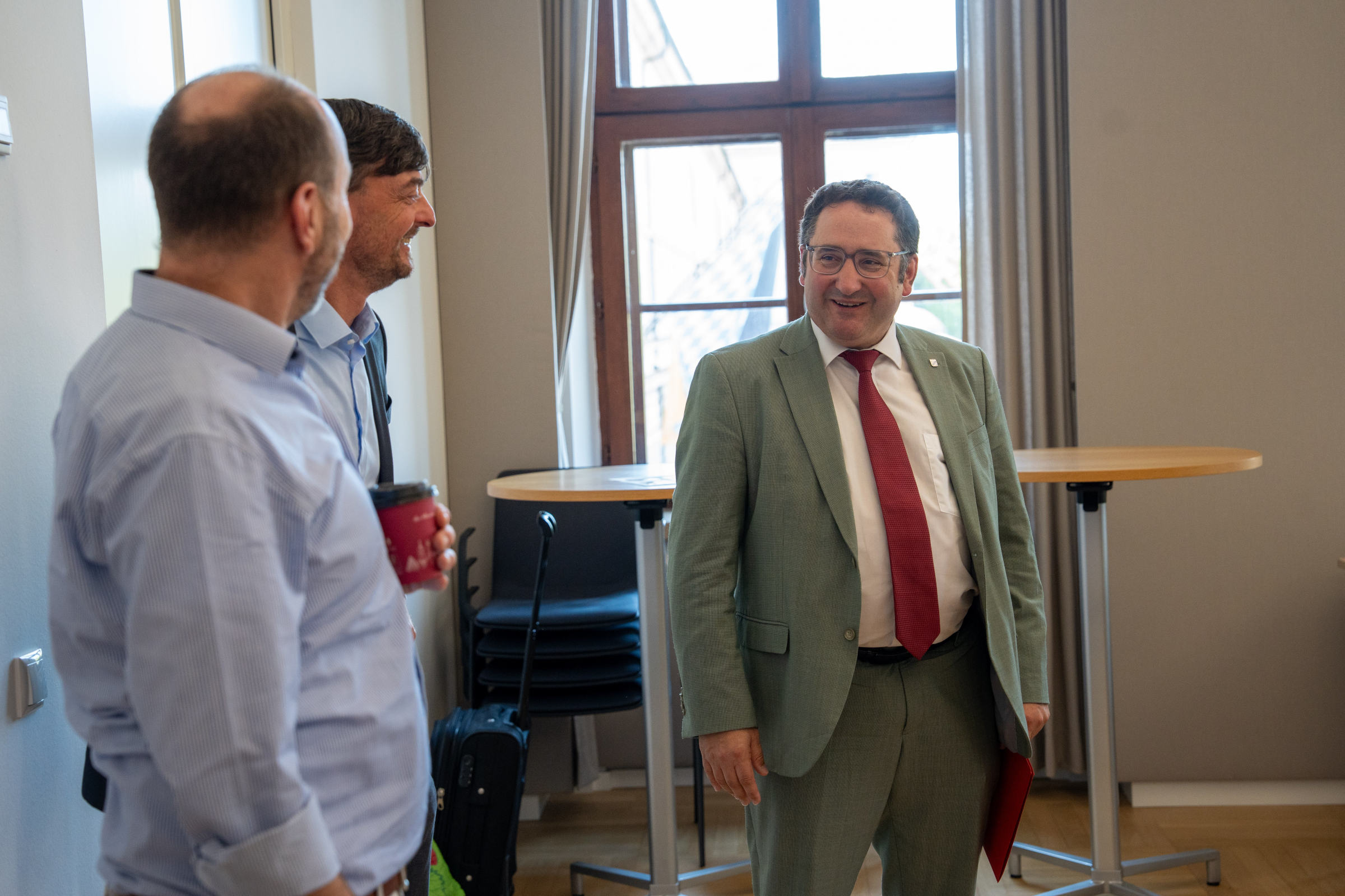 Bayerns Wirtschaftsstaatssekretär Tobias Gotthardt tauscht sich zum grenzüberschreitenden Wissens- und Technologietransfer mit Projektpartnern aus.