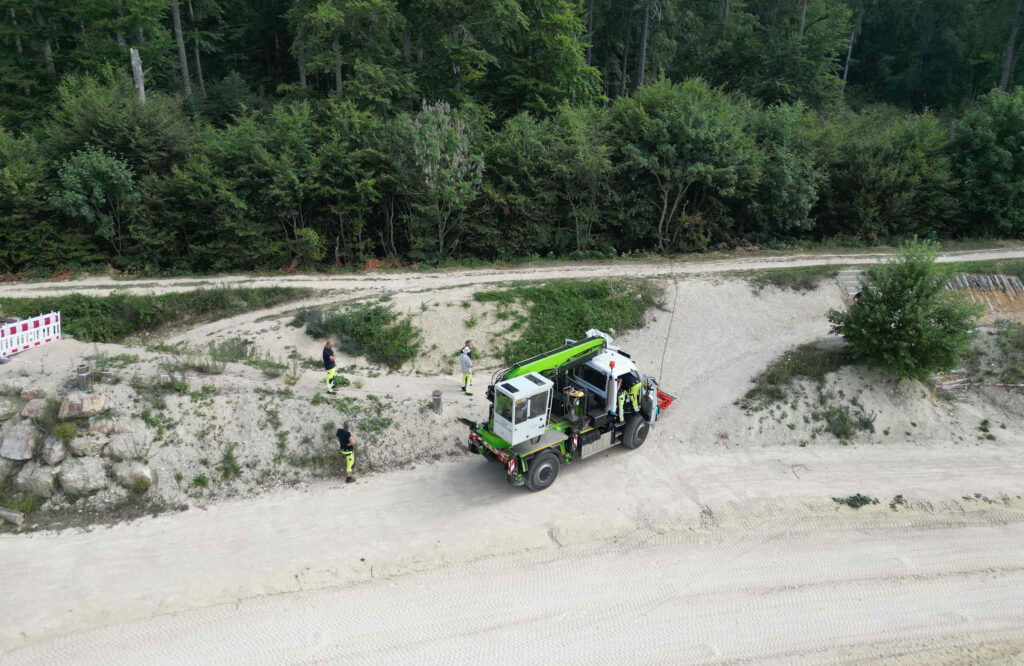 Praxistest im Gelände: Der Unimog Geräteträger mit einem Aufbau der Firma WERNER und Ematec Aufbaubagger im vollen Einsatz.