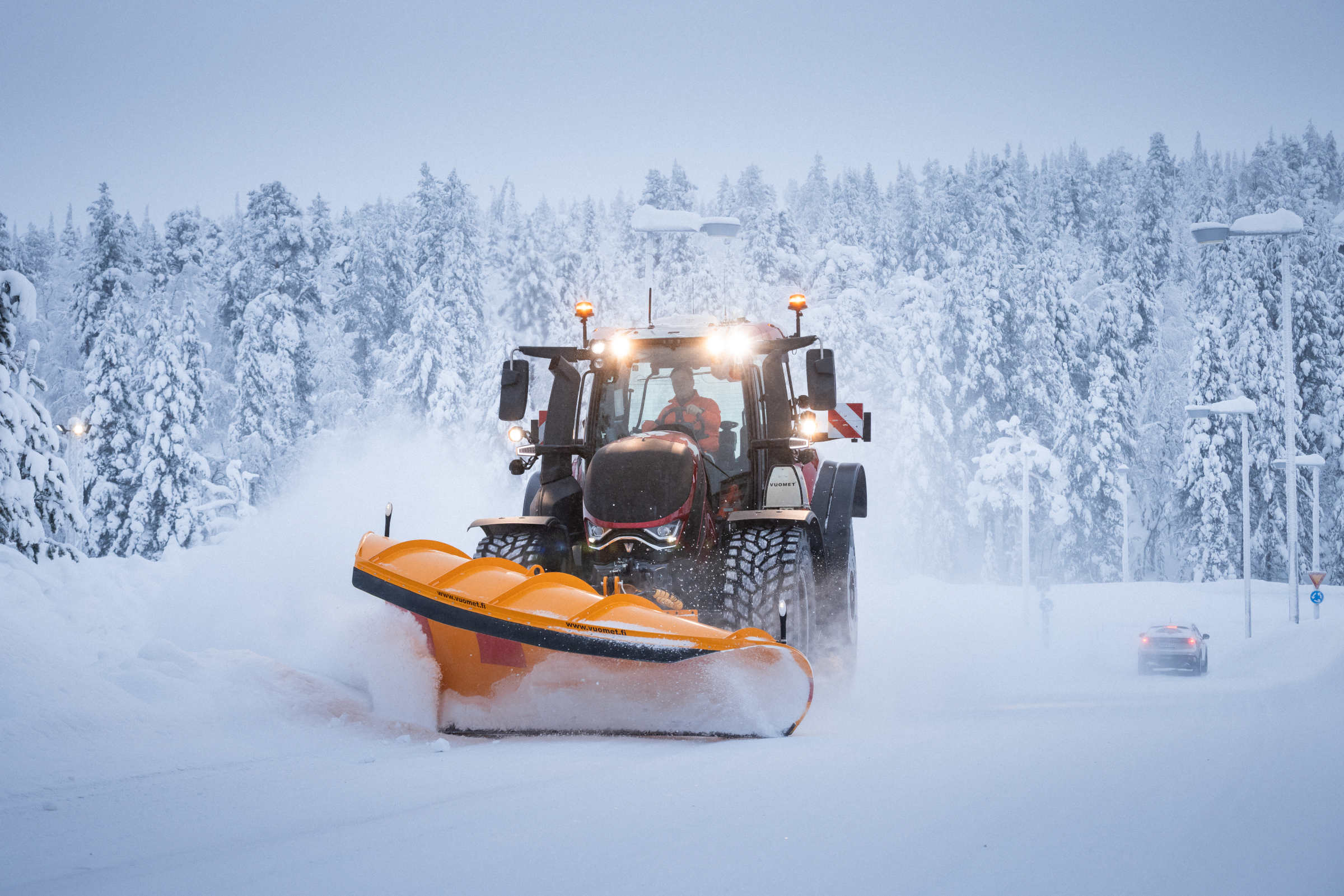Zuverlässige Infrastruktur im Dauerschnee: Die Valtra T-Serie im kommunalen Winterdienst beim Freiräumen tief verschneiter Land- und Waldstraßen. Durch die Kombination aus hoher Motorleistung, optimaler Gewichtsverteilung und professionellen Räumschilden sichern die Maschinen die Mobilität in ländlichen Regionen auch bei extremem Winterwetter.